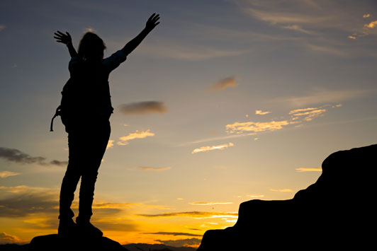 girl hiking outdoors with hands up