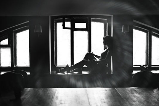 black and white image of girl looking out window