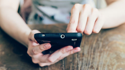 woman pressing finger on phone screen