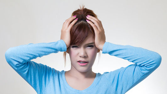 young woman in blue longsleeve shirt holding hands on head