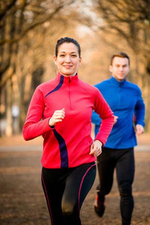 woman in red jogging in front of man in blue