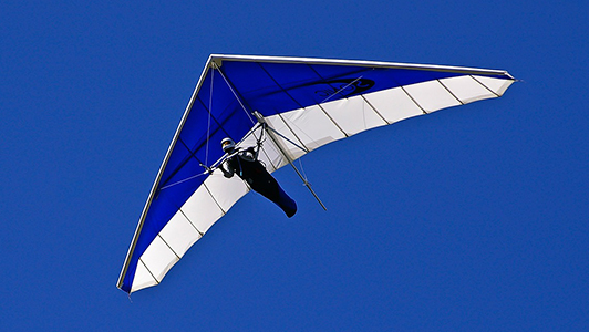 Man hang-gliding over city