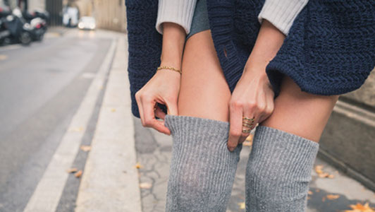 woman pulling up over knee socks