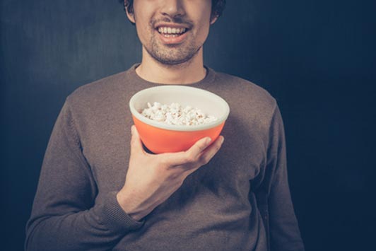 guy holding bowl of popcorn