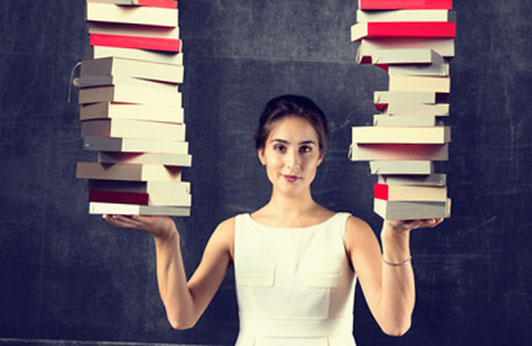 clever woman holding stacks of books