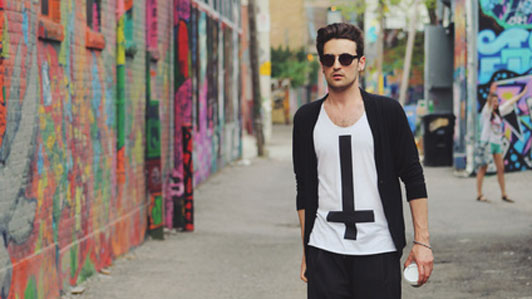 guy with coffee cup walking down colorful street alley