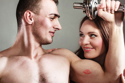 woman's kiss on man's bicep living dumbbell