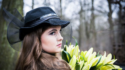 woman in black hat holding flowers