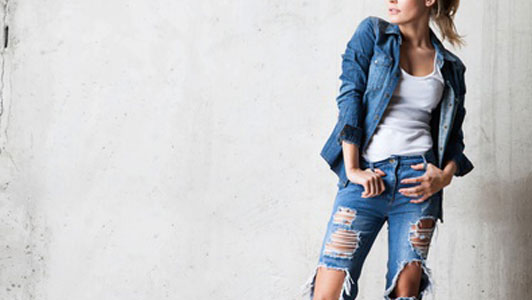 woman in denim jacket wearing jeans with tears