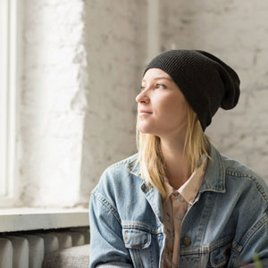 woman in oversized denim jacket wearing black hat