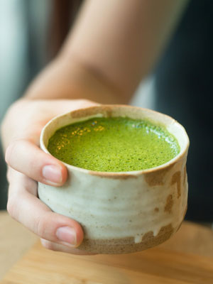 woman holding macha green tea