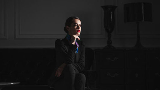 woman in black suit sitting in dark room