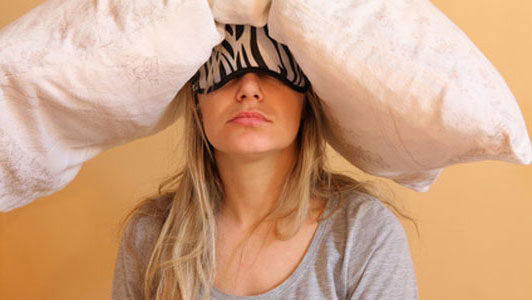 woman waking up with pillow on head