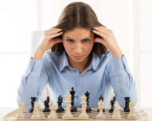 woman sitting in front of chess board