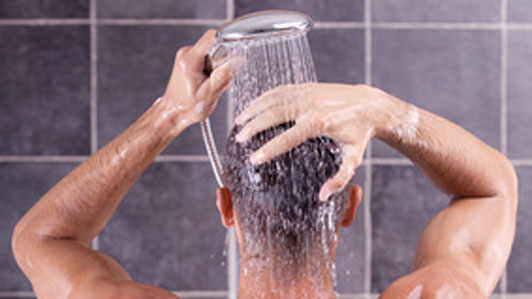guy holding shower head over head