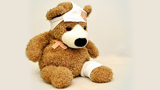 A teddy bear with patches and stitches.