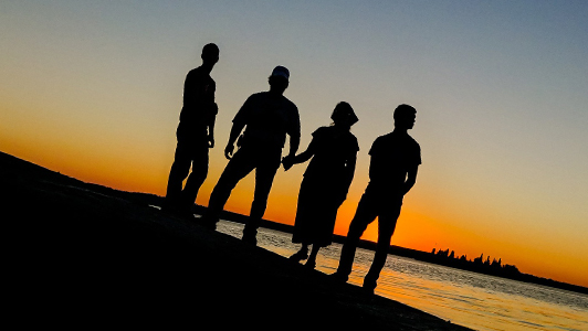 People standing and looking at sunset.